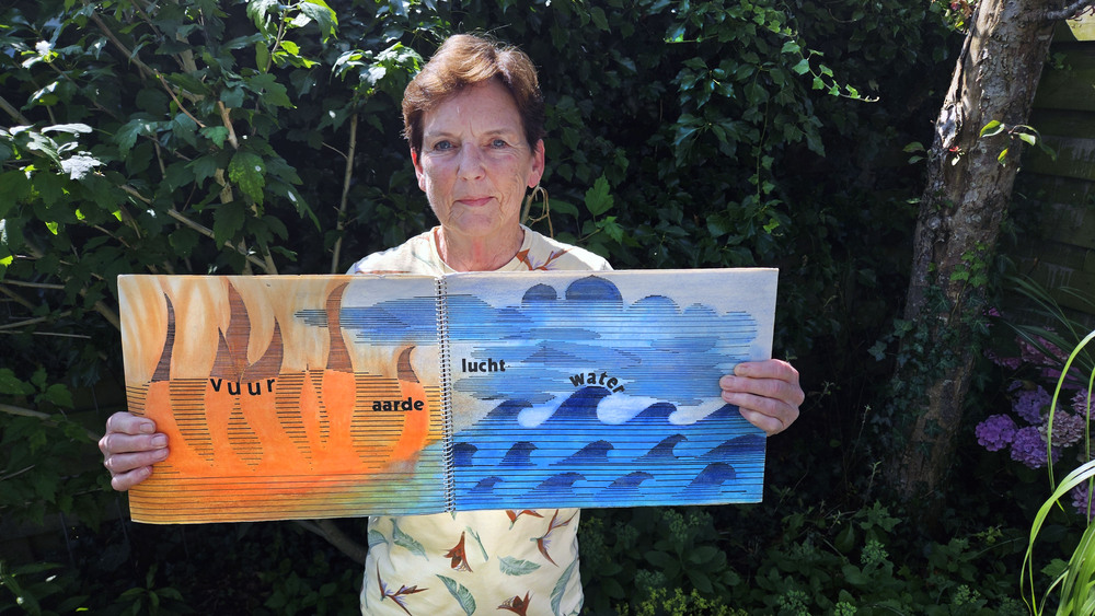 Geeske Winia met haar tekenboek dat ze maakte in de tekenles van Louis Le Roy in 1966 op de Rijks HBS Heerenveen. (foto: Peter Wouda)