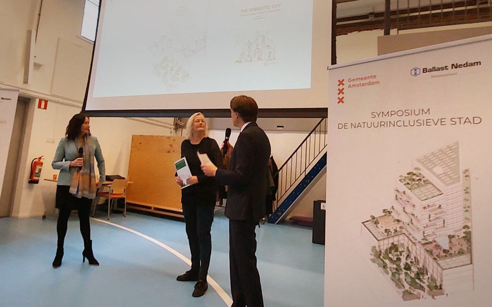 OVerhandiging brochure De Symbiotische stad aan Josja van der Veer van de gemeente Amsterdam